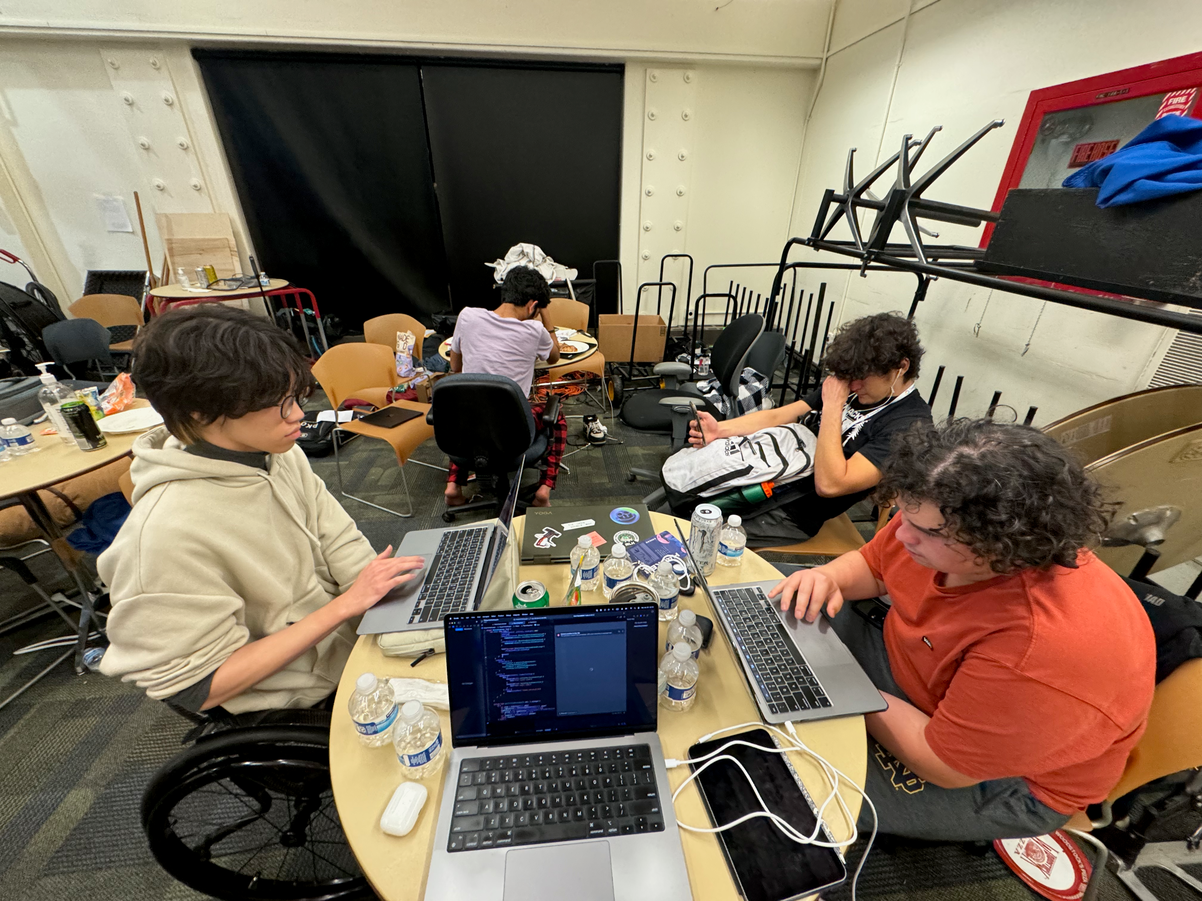 My team sitting around a table, working on the CruzHacks 2024 project. Several laptops are open, including one with Xcode running.