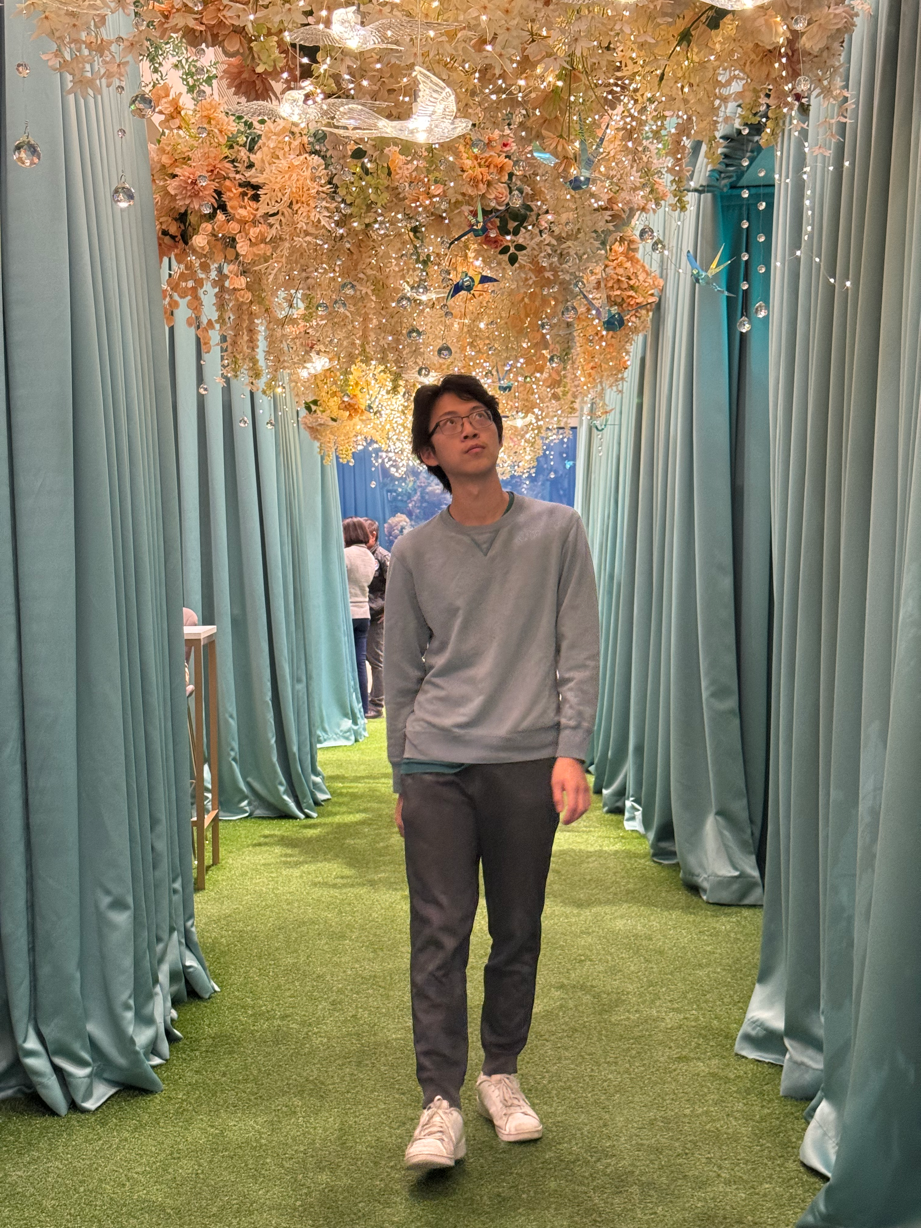 Me walking around under a set of flowers, on the top floor of Taipei 101.